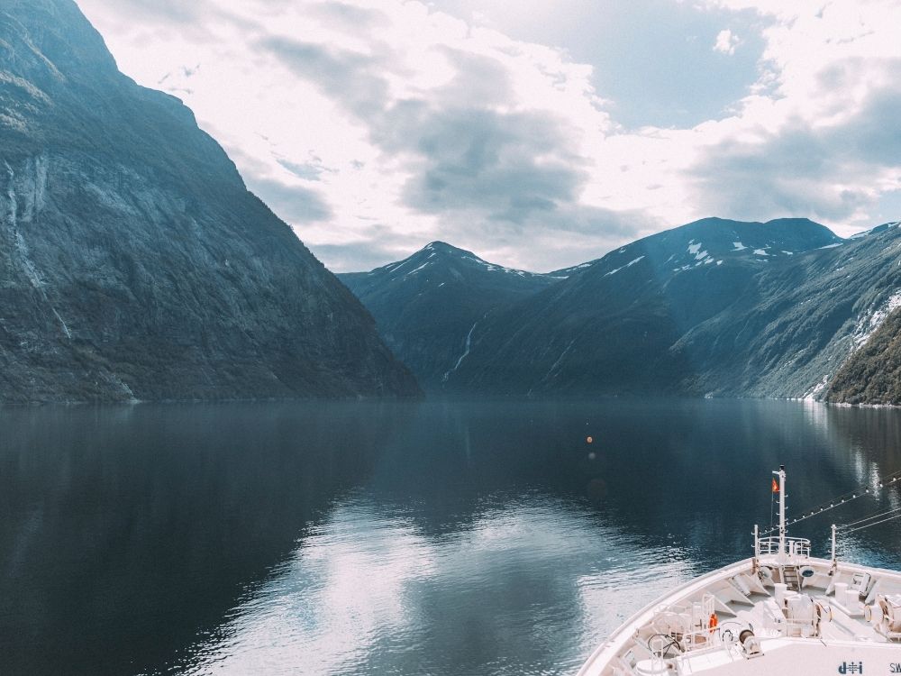 Kreuzfahrtschiff fährt durch norwegischen Fjord mit Blick vom Bug